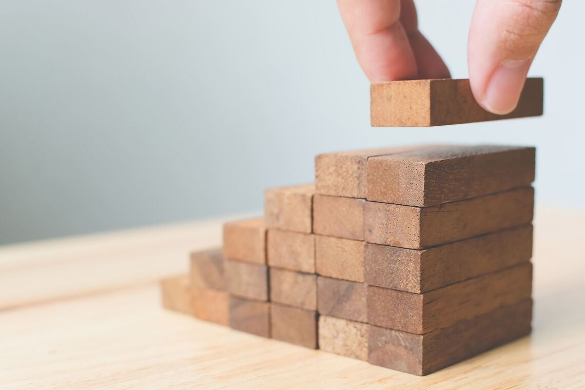 Holzbausteine werden zu einer Treppe gestapelt.